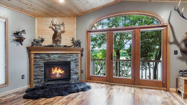 doorway featuring baseboards, wood finished floors, visible vents, and a fireplace