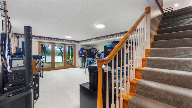 stairs featuring carpet and a textured ceiling