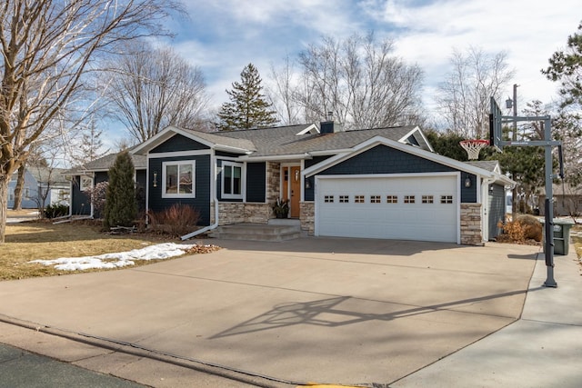 view of front facade featuring stone siding, an attached garage, driveway, and roof with shingles