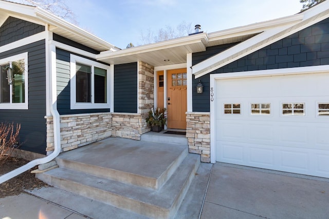 entrance to property featuring stone siding and a garage