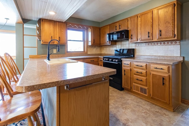 kitchen featuring black appliances, a sink, brown cabinetry, and backsplash