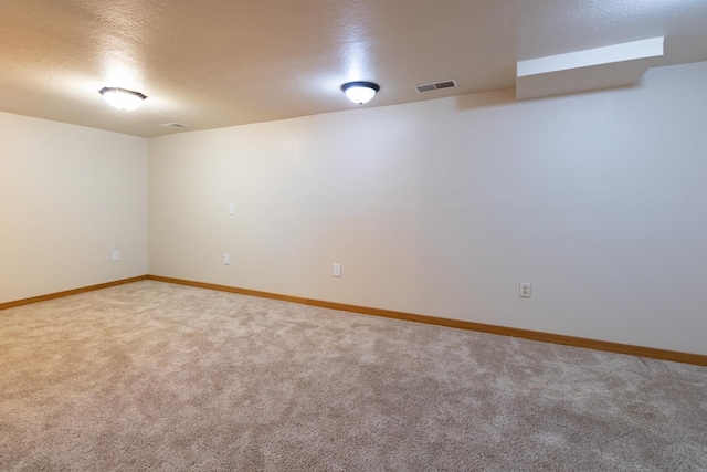 carpeted spare room with baseboards and a textured ceiling