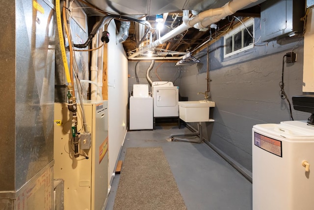 unfinished below grade area with washer and clothes dryer and a sink