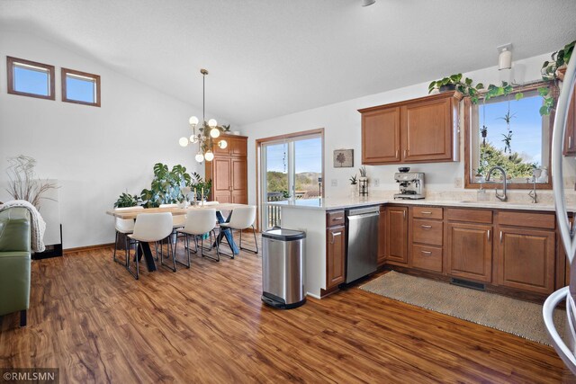 kitchen with stainless steel dishwasher, dark wood-style floors, light countertops, and a sink