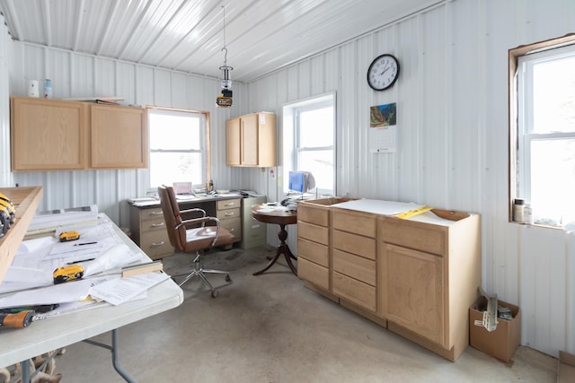 office area with concrete flooring and metal wall