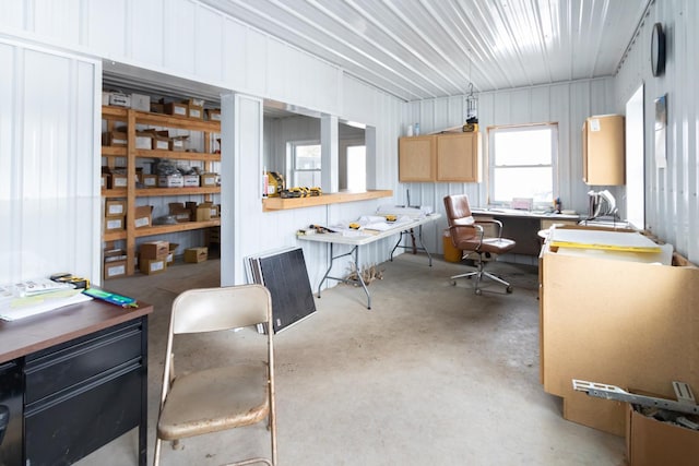 kitchen featuring concrete floors, light brown cabinets, and metal wall