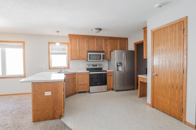 15174 Cates Lake Dr, Savage, MN 55372 - kitchen featuring stainless steel appliances, light countertops, a sink, a peninsula, and brown cabinetry