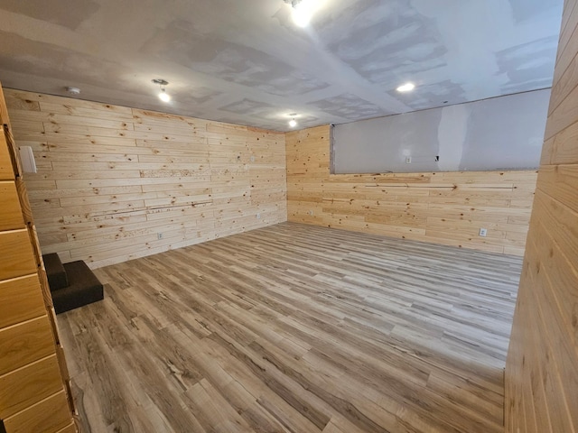finished below grade area featuring wooden walls and wood finished floors
