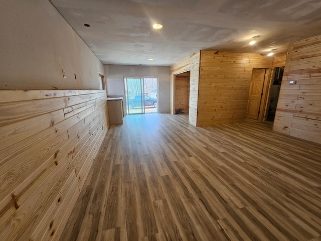 unfurnished living room with wooden walls and wood finished floors