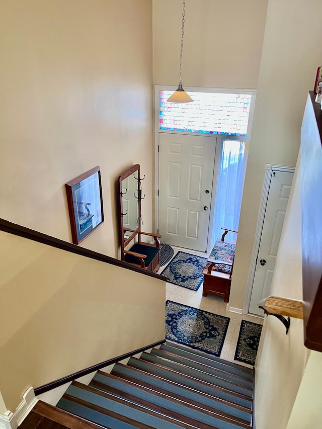 entryway featuring stairway, a high ceiling, and baseboards