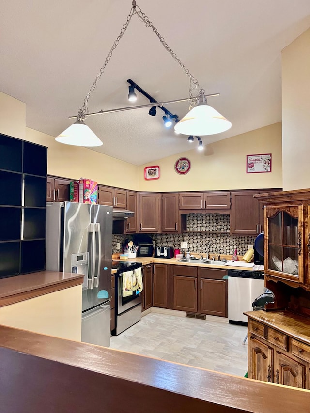 kitchen featuring stainless steel appliances, a sink, backsplash, and light countertops