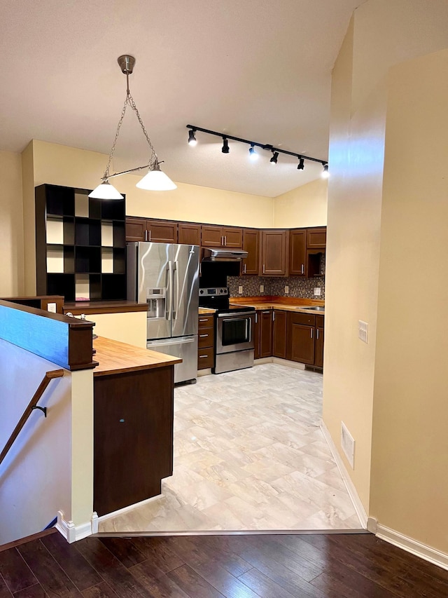kitchen featuring stainless steel appliances, track lighting, dark brown cabinets, baseboards, and tasteful backsplash