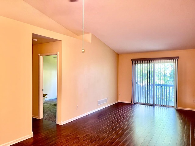 spare room featuring dark wood finished floors, baseboards, and vaulted ceiling