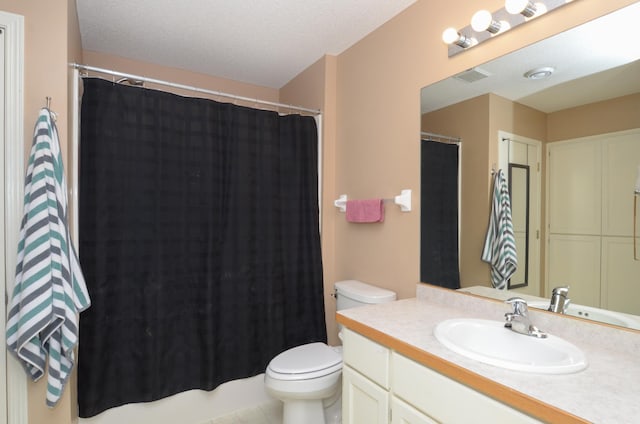 bathroom featuring toilet, vanity, and curtained shower
