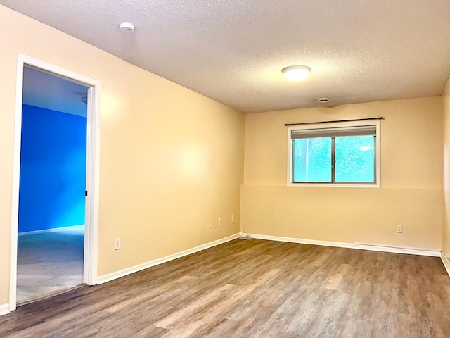 953 14th Ln SE, Cambridge, MN 55008 - empty room with wood finished floors, a textured ceiling, and a smoke detector
