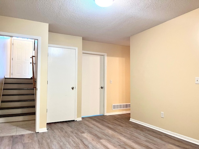 953 14th Ln SE, Cambridge, MN 55008 - unfurnished bedroom with wood finished floors, a textured ceiling, and a closet