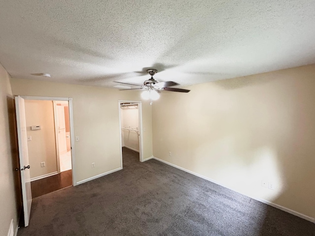 953 14th Ln SE, Cambridge, MN 55008 - unfurnished bedroom with a textured ceiling, dark carpet, a spacious closet, and ceiling fan