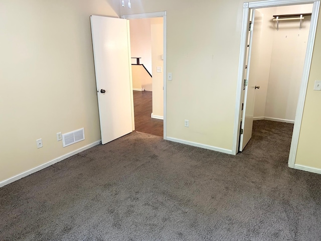 953 14th Ln SE, Cambridge, MN 55008 - unfurnished bedroom featuring dark carpet and a walk in closet