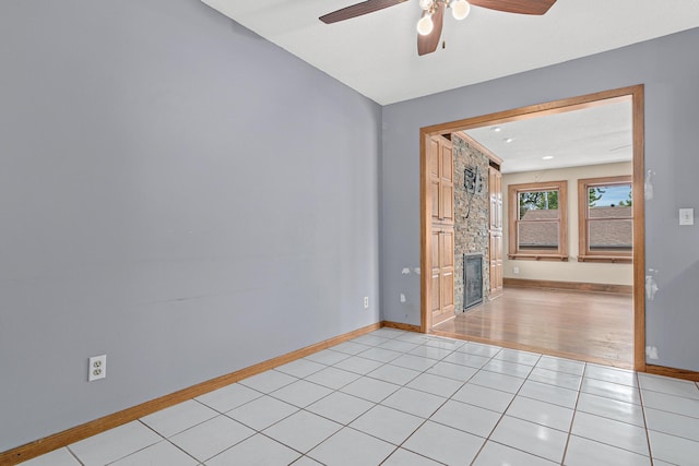 4418 Chowen Ave N, Robbinsdale, MN 55422 - spare room with a fireplace, a ceiling fan, baseboards, and light tile patterned floors