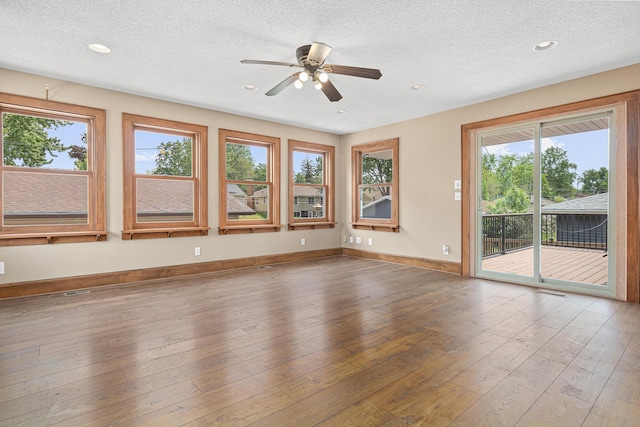 4418 Chowen Ave N, Robbinsdale, MN 55422 - empty room featuring healthy amount of natural light, a textured ceiling, a ceiling fan, wood-type flooring, and recessed lighting