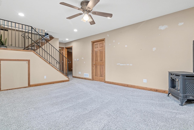 4418 Chowen Ave N, Robbinsdale, MN 55422 - unfurnished living room with a wood stove, carpet floors, baseboards, stairway, and ceiling fan