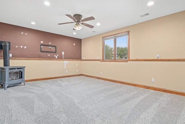 4418 Chowen Ave N, Robbinsdale, MN 55422 - unfurnished living room with carpet, a ceiling fan, a wood stove, recessed lighting, and baseboards