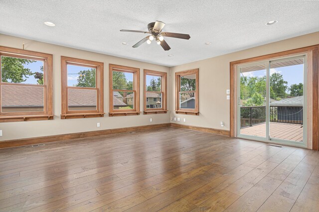 4418 Chowen Ave N, Robbinsdale, MN 55422 - spare room featuring healthy amount of natural light, a textured ceiling, ceiling fan, wood-type flooring, and recessed lighting