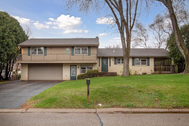 split level home with a garage, aphalt driveway, a front lawn, and brick siding