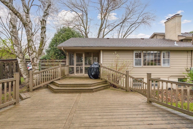wooden deck with fence and a sunroom