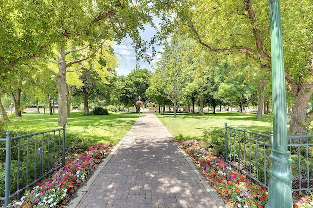 view of home's community with a yard and fence