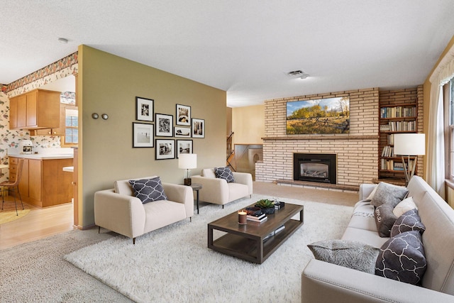 living area with plenty of natural light, a fireplace, visible vents, and light carpet