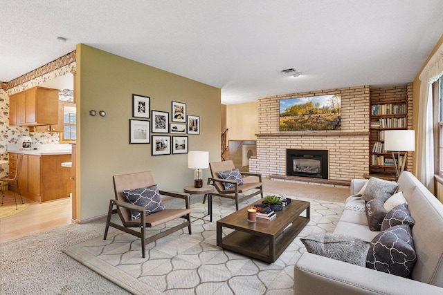 living room featuring visible vents, light carpet, a brick fireplace, and a wealth of natural light