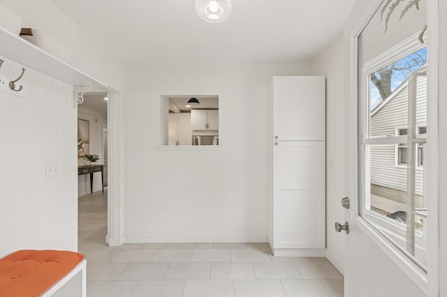 interior space with light tile patterned floors and baseboards
