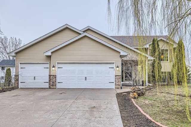 view of front of house with a garage, stone siding, and concrete driveway
