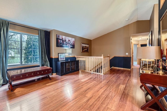 living room featuring vaulted ceiling and wood finished floors