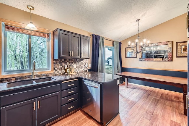 kitchen with an inviting chandelier, vaulted ceiling, dishwasher, a sink, and light wood-style flooring
