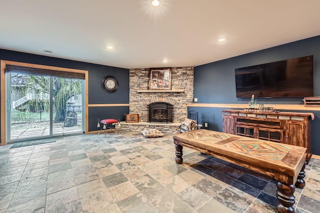 living area with recessed lighting, stone tile floors, baseboards, and a fireplace