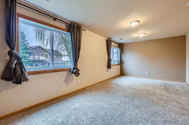 empty room featuring carpet floors and baseboards