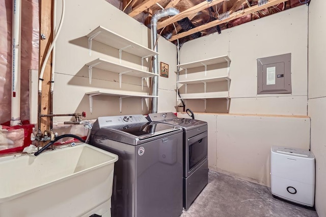 clothes washing area with washer and clothes dryer, a sink, laundry area, and electric panel