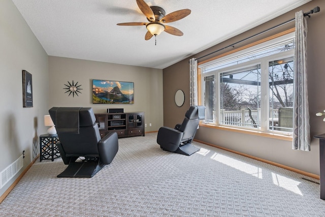living room featuring a ceiling fan, baseboards, and carpet floors