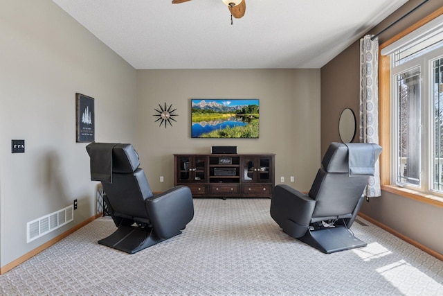 living area with baseboards, a ceiling fan, visible vents, and carpet