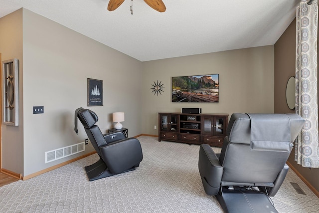 carpeted living area featuring visible vents, baseboards, and ceiling fan