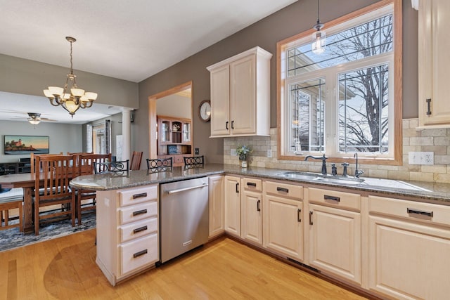 kitchen featuring dishwasher, decorative backsplash, a sink, and light wood-type flooring