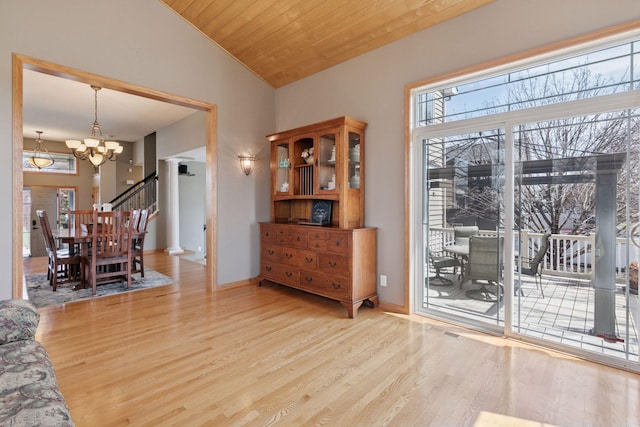 interior space featuring baseboards, vaulted ceiling, wood finished floors, and an inviting chandelier