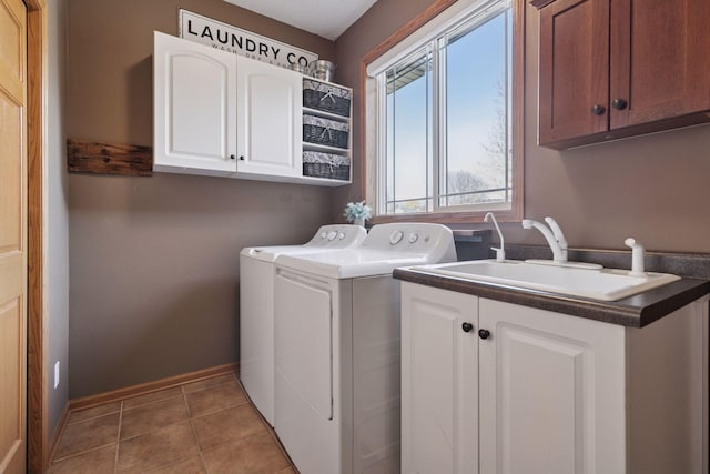 laundry area featuring a sink, washer and dryer, cabinet space, baseboards, and tile patterned flooring