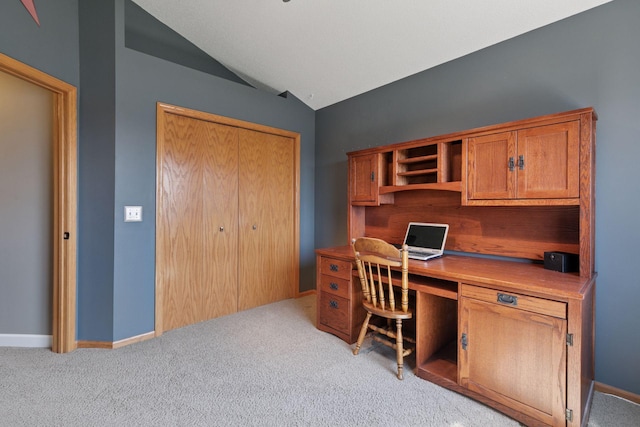 office space with light colored carpet, lofted ceiling, and baseboards