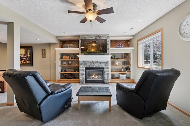 carpeted living area featuring visible vents, a ceiling fan, baseboards, a fireplace, and a textured ceiling