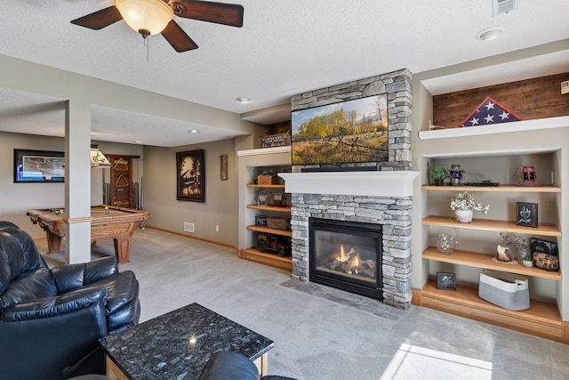 carpeted living area with a textured ceiling, baseboards, a ceiling fan, billiards, and a fireplace