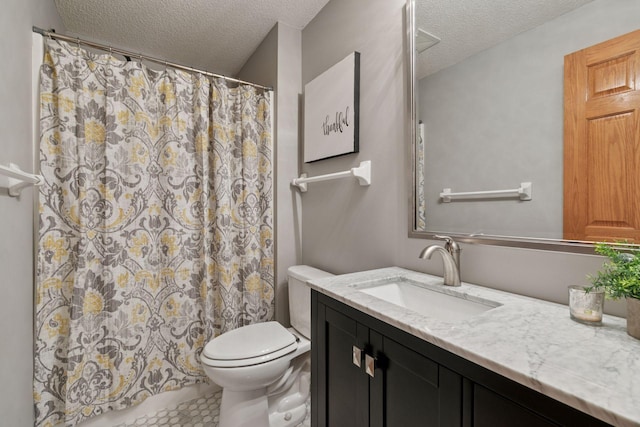 bathroom with tile patterned floors, vanity, a textured ceiling, and toilet