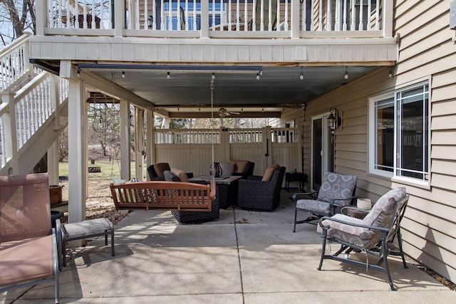 view of patio / terrace with an outdoor living space, fence, and stairs